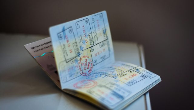 Passport with multiple visas and immigration stamps representing extraordinary ability visa options