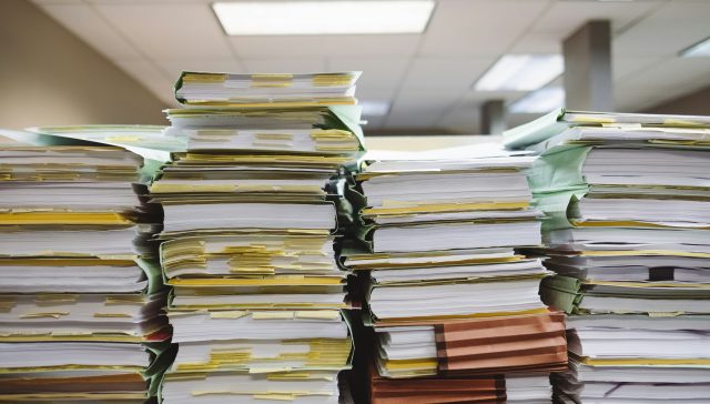Stacks of immigration documents representing the complexity of U.S. immigration processes