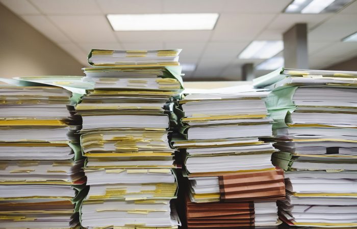 Stacks of immigration documents representing the complexity of U.S. immigration processes