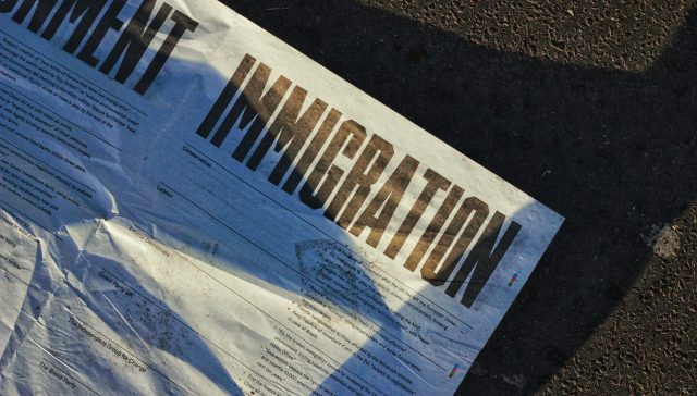 Newspaper featuring immigration headlines representing O-1B visas and EB-1 green card options for artists and creative professionals.