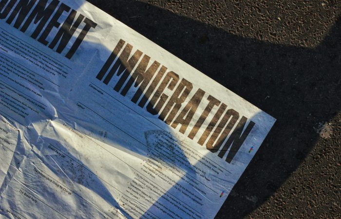 Newspaper featuring immigration headlines representing O-1B visas and EB-1 green card options for artists and creative professionals.