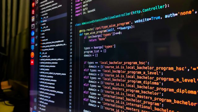 Software engineer working with code on a computer for an EB-2 NIW immigration case