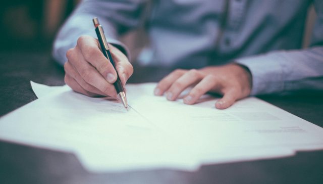 Professional reviewing documents for EB-2 NIW and O-1A immigration options