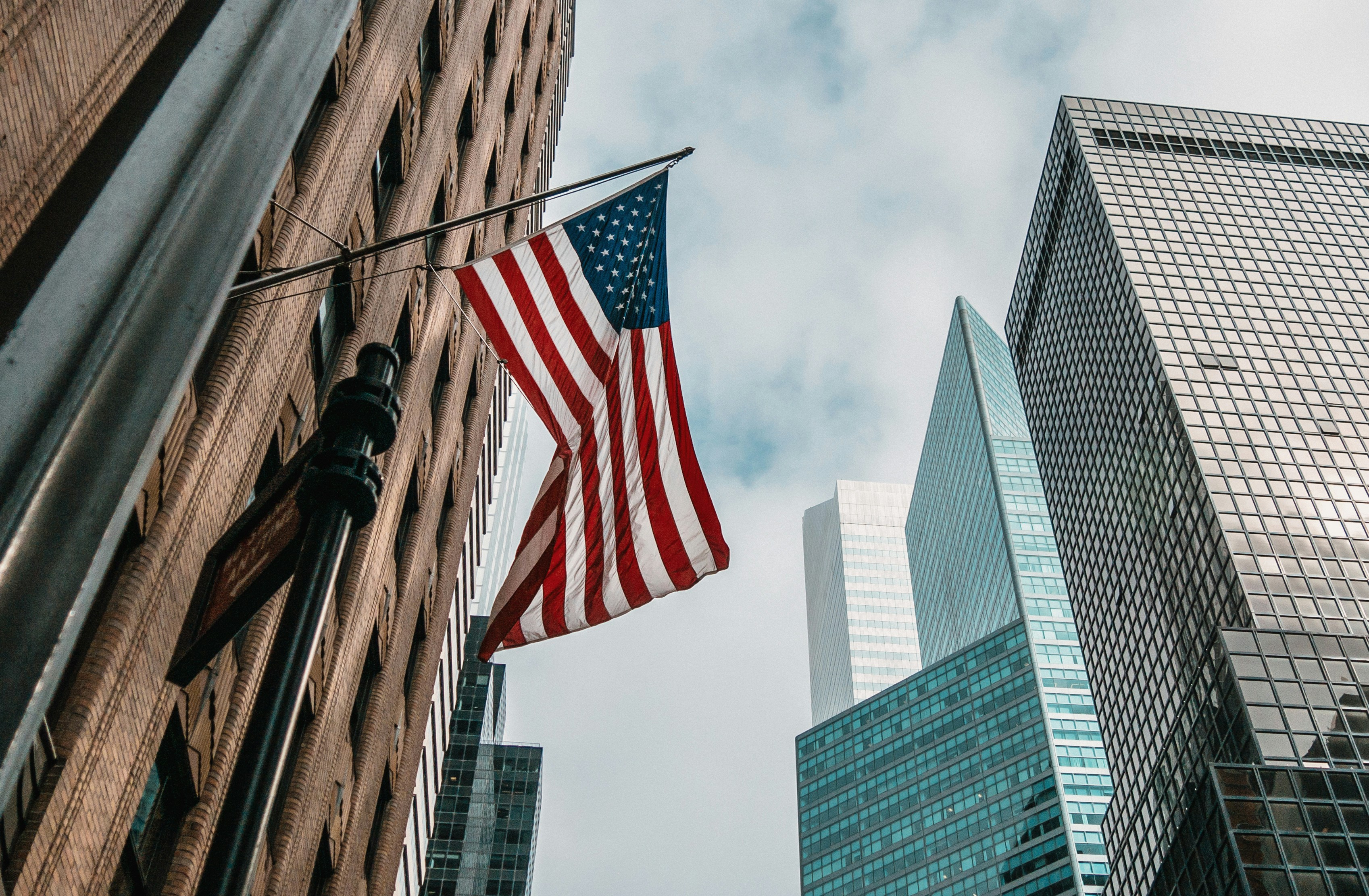 U.S. flag surrounded by modern office buildings in a major American city