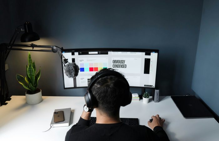 Graphic designer working on a computer at a desk with a color palette displayed on the monitor