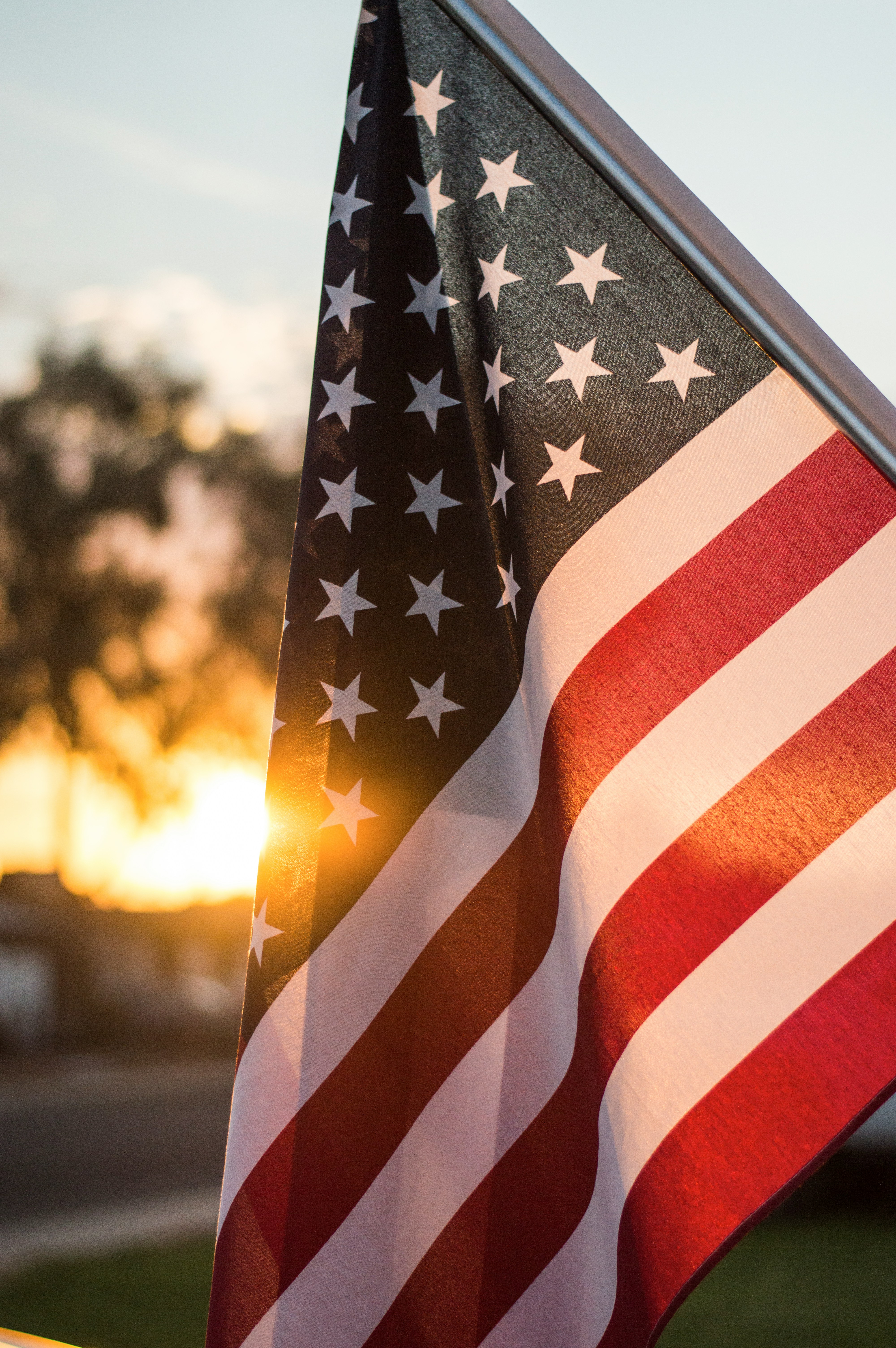 American flag waving against a sunset sky representing U.S. immigration opportunities