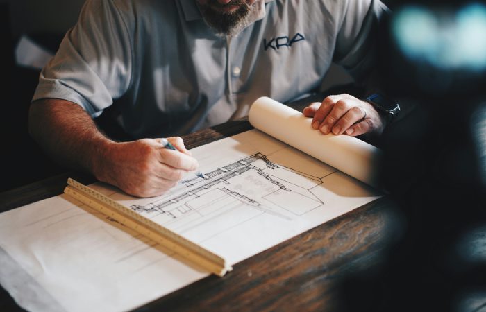 An architect reviewing architectural blueprints and drafting designs for a U.S. immigration petition.