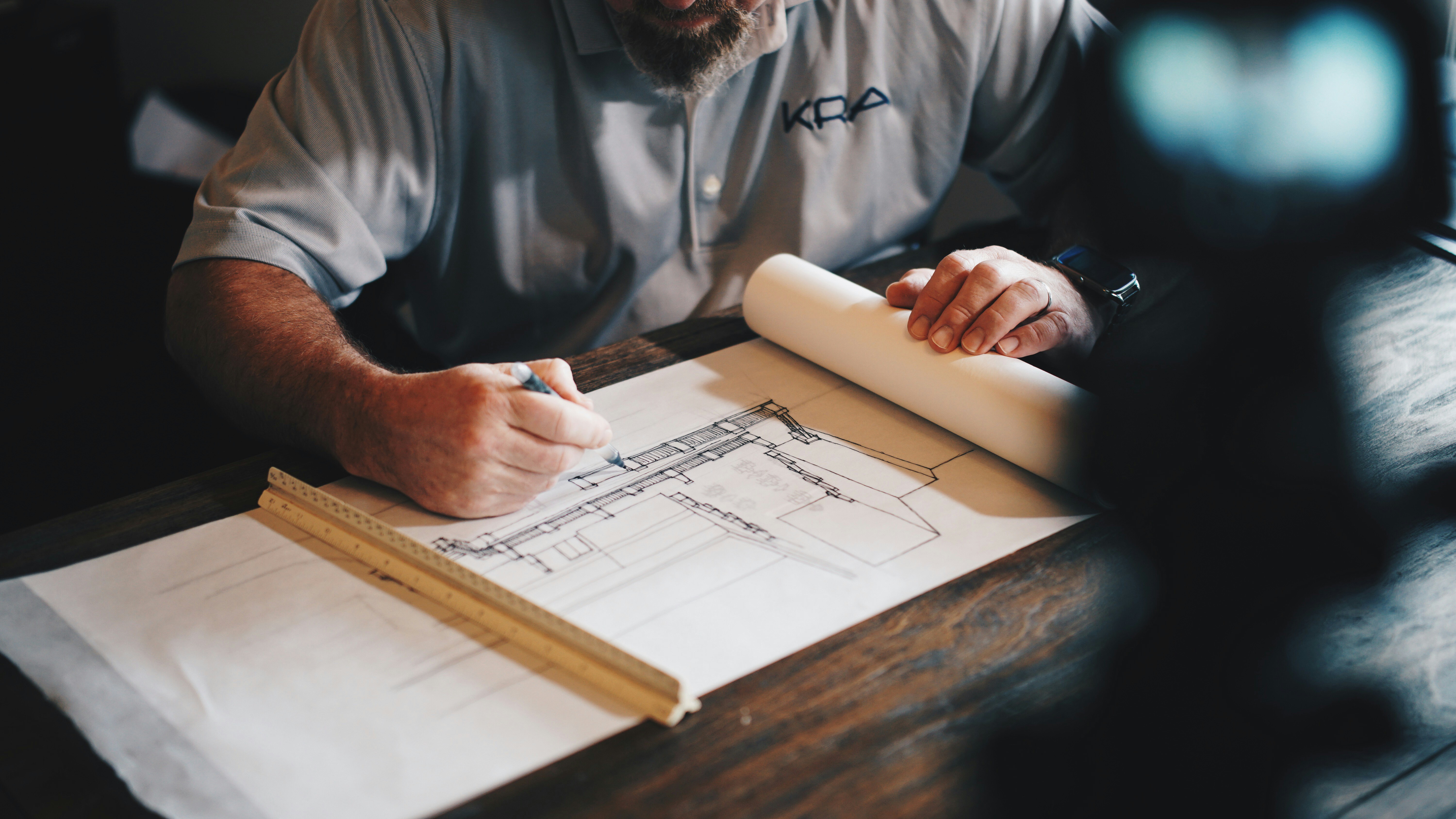 An architect reviewing architectural blueprints and drafting designs for a U.S. immigration petition.