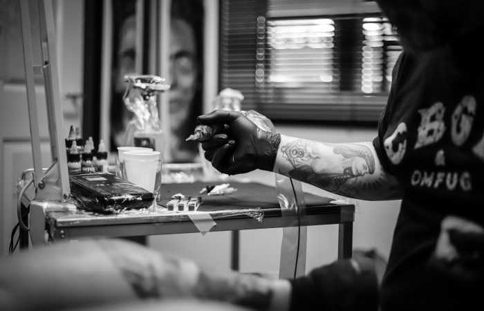Tattoo artist holding a tattoo machine in a studio setting