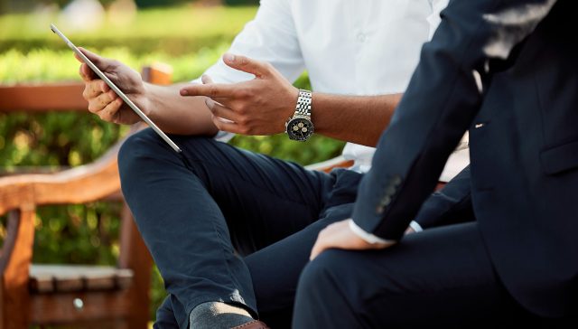 Business professionals reviewing corporate strategy on a tablet for an EB-2 NIW petition