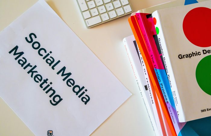 A desk showing materials on social media marketing and graphic design representing marketing leaders exploring the O-1A visa.